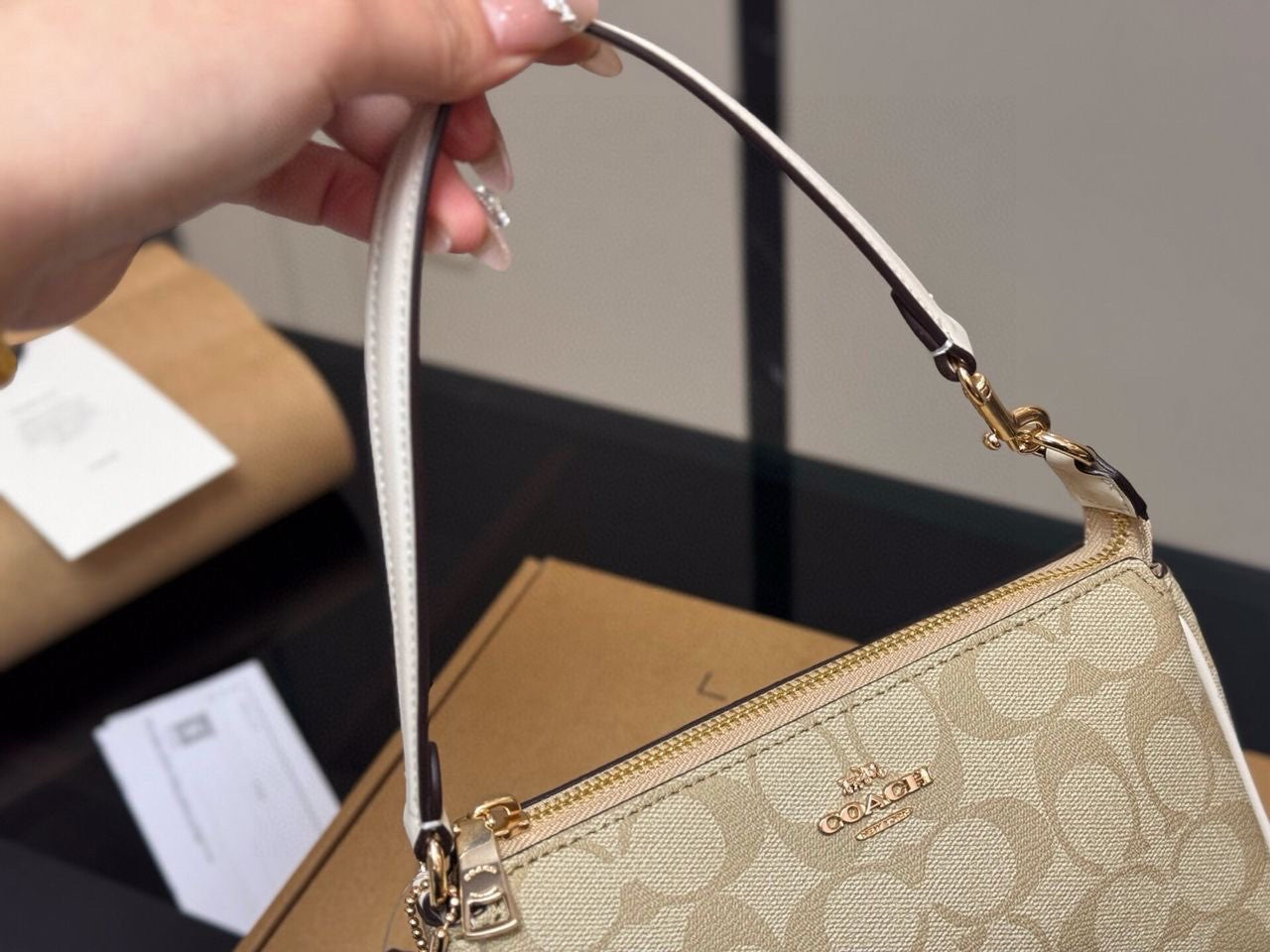 Le sac Coach beige petit format est conçu avec un cuir de haute qualité