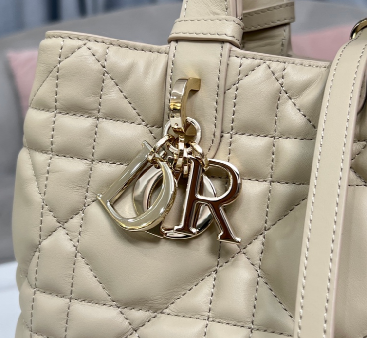 Sac Lady Dior beige matelassé avec breloques dorées